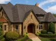 Tudor-style home with 30-year asphalt shingles and detailed stone façade